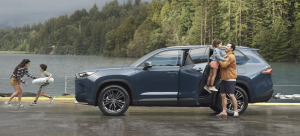 family of four exiting blue 2025 Toyota highlander in nature setting